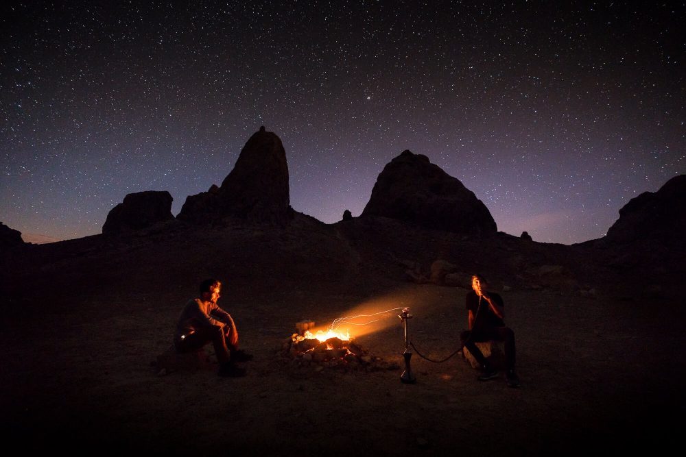 jake landon schwartz and tyler minney sit around a fire under the stars at trona pinnacles | photo by jake landon schwartz