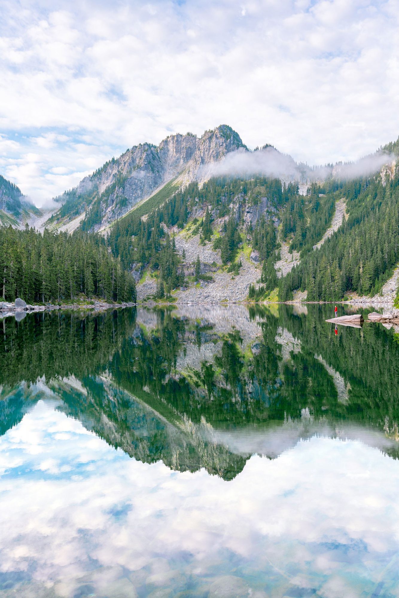 a woman looks out over glacier lake in the alpine lakes wilderness east of seattle in washington | photo by jake landon schwartz