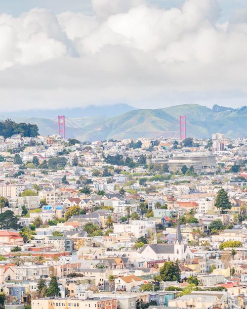 a view of the golden gate bridge behind the sprawl of san francisco as seen from bernal heights
